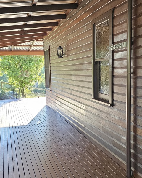 A repainted weatherboard home with a timber deck