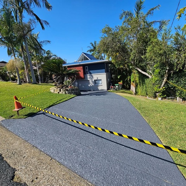 A coated driveway leading to a home exterior