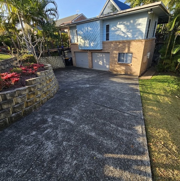 A freshly sealed driveway beside a home
