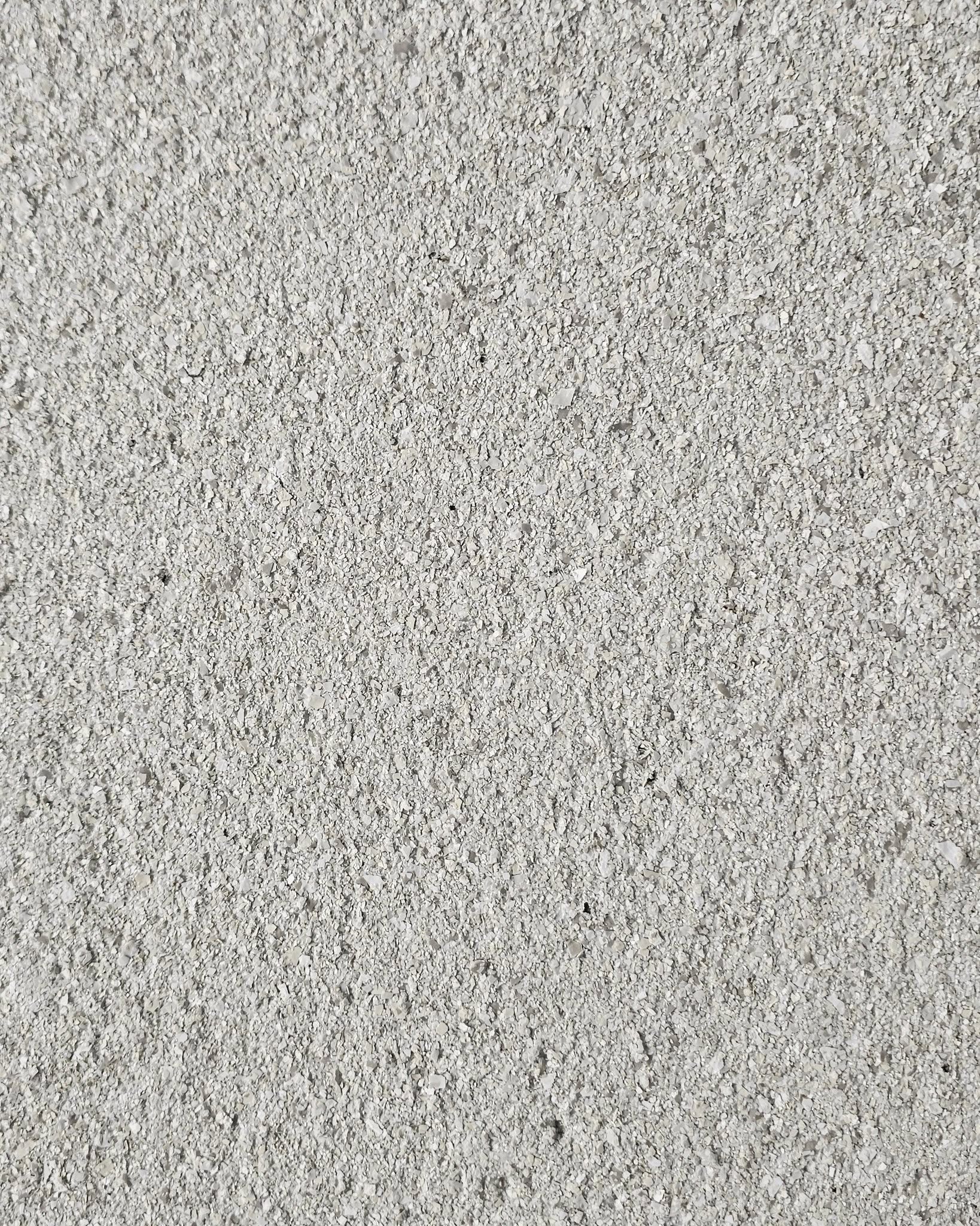 A textured render wall coating in a soft grey finish